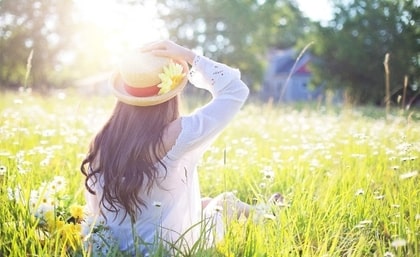 Una ragazza in un campo di fiori al mattino, sole, luce.