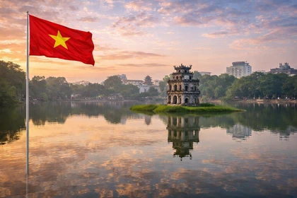 Lago Hoàn Kiếm ad Hanoi, capitale del Vietnam, con la Torre della Tartaruga e la bandiera nazionale