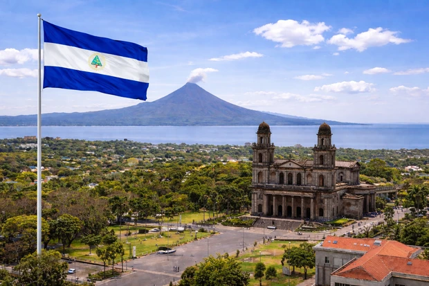 Managua, capitale del Nicaragua, con il lago Xolotlán, il vulcano Momotombo e la bandiera nazionale