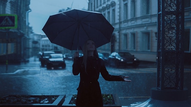 Una ragazza sotto la pioggia, nuvoloso, nero, ombrello. Quiz Idrosfera.